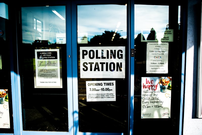 Glass door of a polling station with signs about voting 