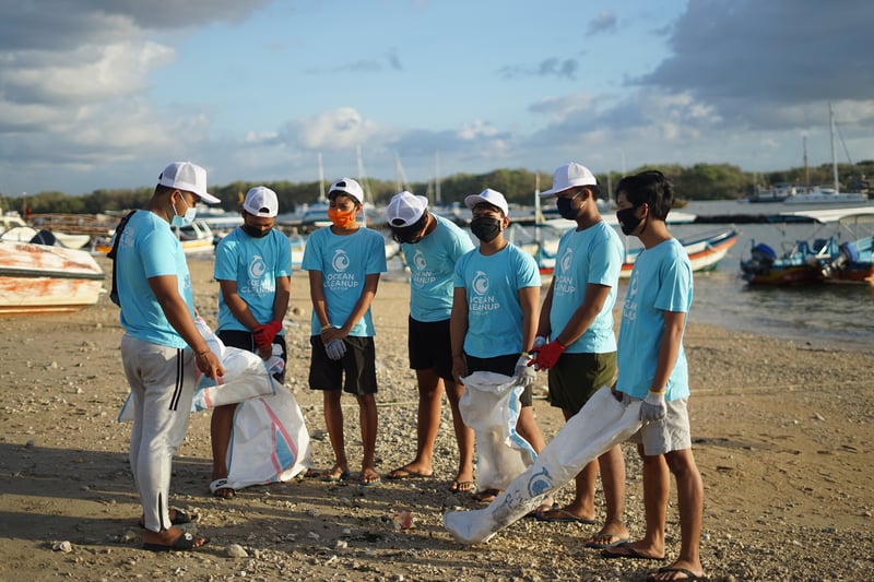 Seven students volunteering with a nonprofit to help clean up a beach